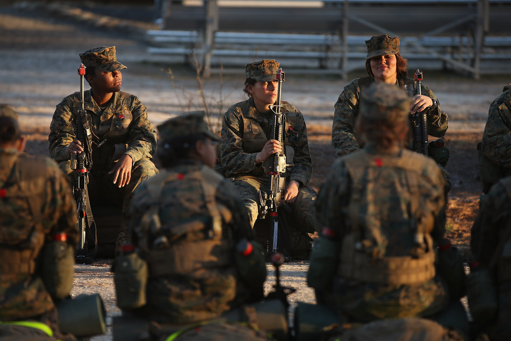 Чоловіки і жінки чекають початку 15-кілометрового нічного маршу в рамках курсу морської бойової підготовки (MCT), 21 лютого 2013 року. Курс проходить на Базі морської піхоти Кемп-Леджен в Джексонвілл, Північна Кароліна. 