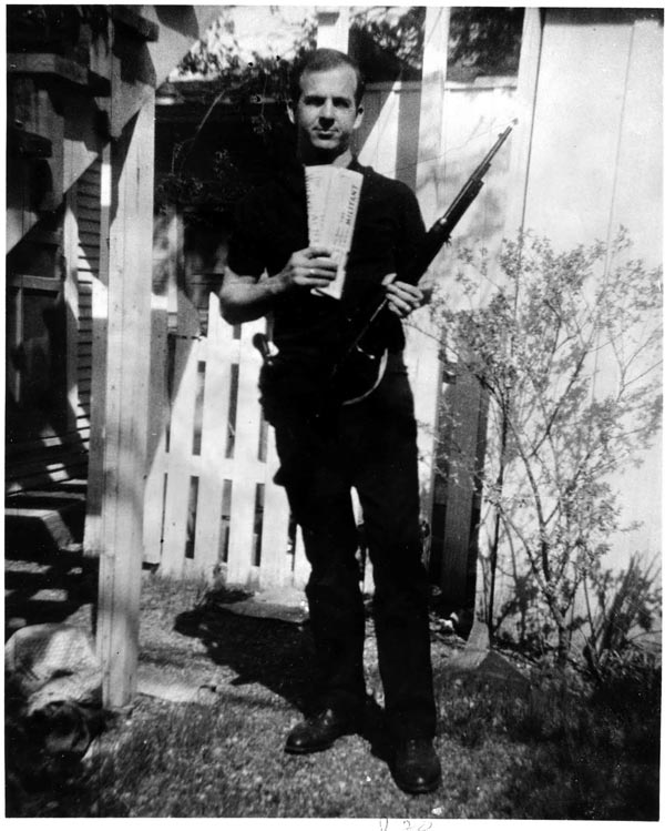 Ли Харви Освальд вместе со своей винтовкой позирует на своем заднем дворе
