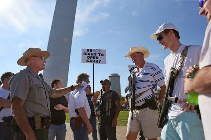 Джеффри Смит (второй справа) и его сын Кевин Смит благодарят работника правоохранительных органов Майка Хортона за его помощь в обеспечении законности акции «Open Carry Firearm Walk», в рамках которой мирное шествие прошло центром города.
