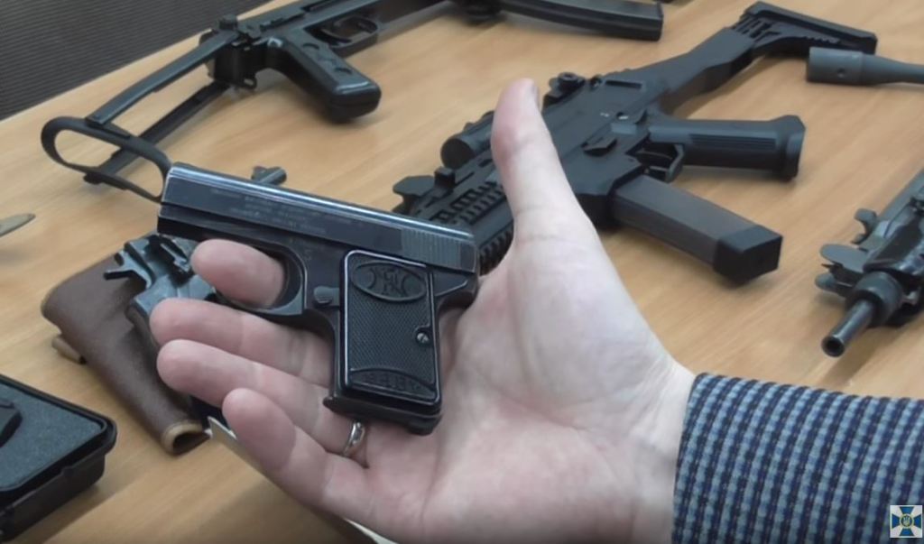 Small FN pistol “Baby”, possibly this one, and the CZ Evo 3 and an Uzi in the background.