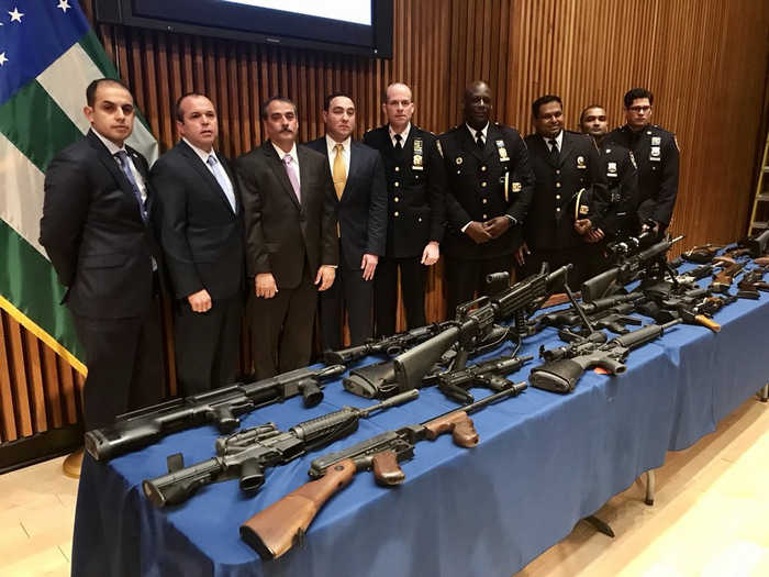 Полицейские позируют на фоне конфискованного оружия 16 апреля 2018 г.
