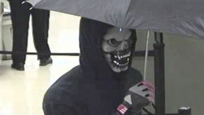 Человек в маске и с зонтиком в руках достал оружие и потребовал у кассира деньги