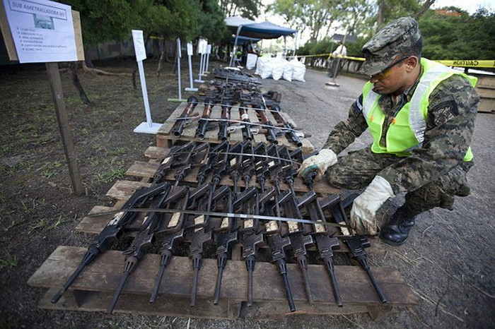 Военнослужащий Гондураса осматривает нелегальное оружие перед его уничтожением