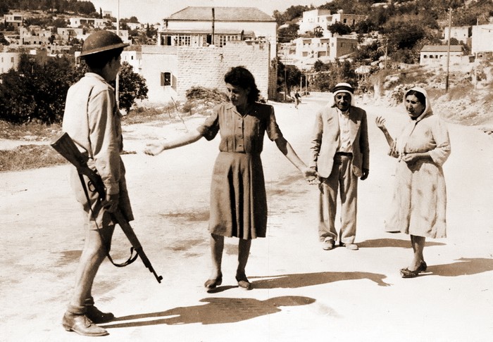 Израильский солдат, вооружённый винтовкой «Маузер» 98k, преграждает дорогу арабской семье