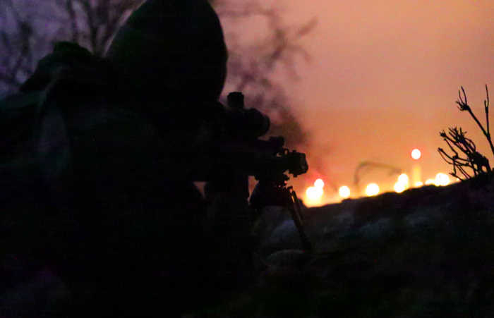 Снайпер Добровольческих сил национальной обороны наблюдает за позициями «противника» во время ночных маневров в ходе учений Allied Spirit VIII