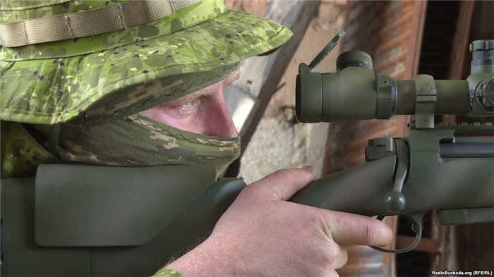 Український снайпер стежить за місцевістю крізь оптику прицілу