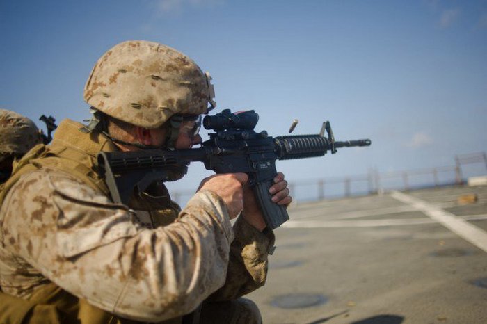 Морской пехотинец стреляет из карабина M4.