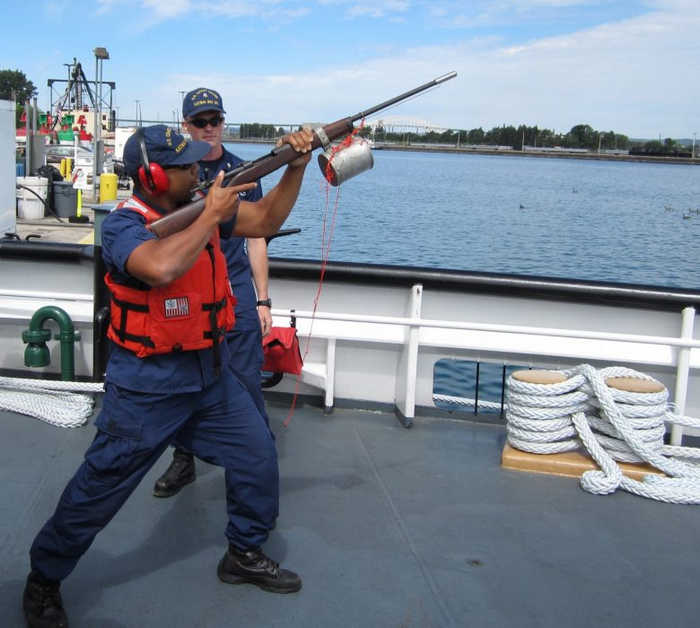 Офіцер берегової охорони Райан Сміт показує, як правильно тримати рушницю для метання буксирувального линя.