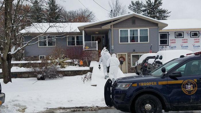 Експерти-криміналісти заходять до будинку, де була застрелена жінка