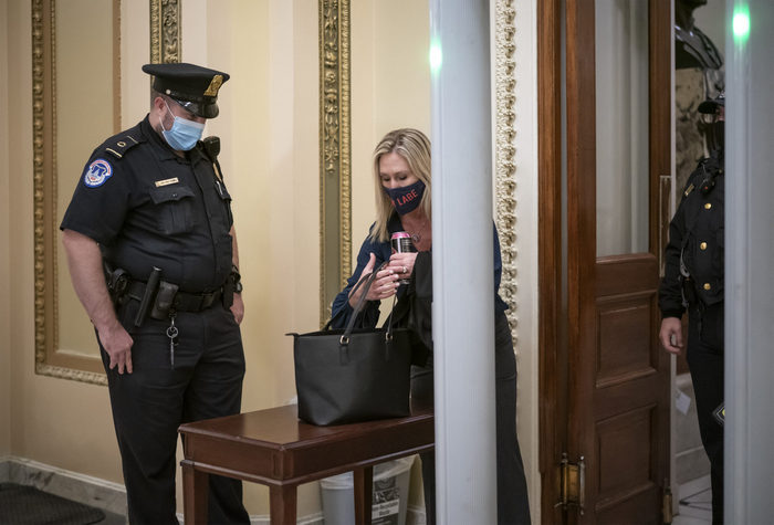 Член Палати представників Марджорі Грін проходить через рамку металошукача, яку встановили після січневих заворушень у Вашингтоні.
