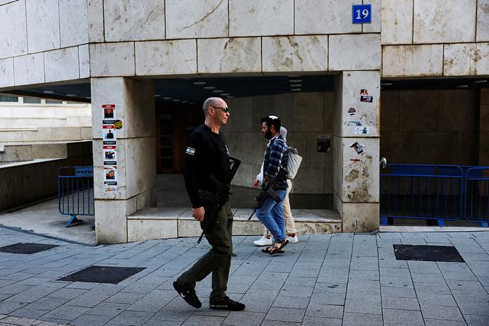Поліцейський проходить повз чоловіка з гвинтівкою в Тель-Авіві, Ізраїль, 10 лютого 2024 року. Фото: Reuters 