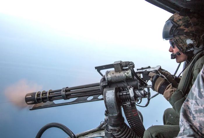 Морський піхотинець стріляє з мінігана, встановленого в дверях вертольота UH-1Y. 