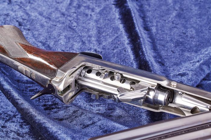 У нижній частині ствольної коробки, поруч зі спущеним курком, можна побачити основу перфорованої трубки магазина разом з її подавачем. Перед нею розташовані дві оболонки підйомника. Ззаду, біля переходу від трубки магазину до прикладу, знаходиться важіль роз'єднувача. Два пази в задній частині затвора відповідають двом пазам у задній частині подовжувача ствола.